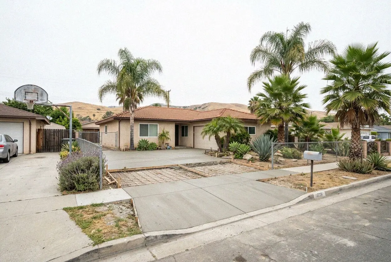A long shared concrete driveway between two houses on a deep Lawndale lot